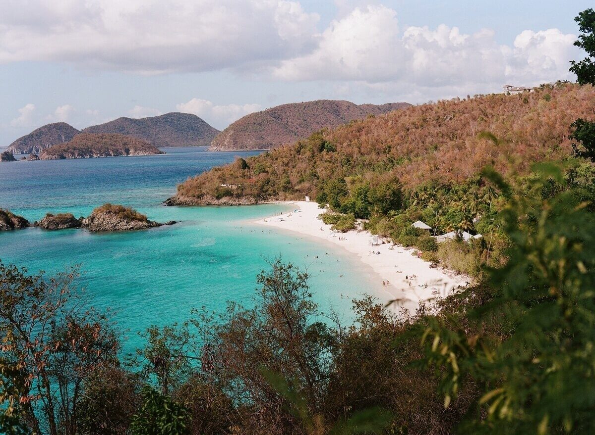 View of clear blue waters and tree lined coast